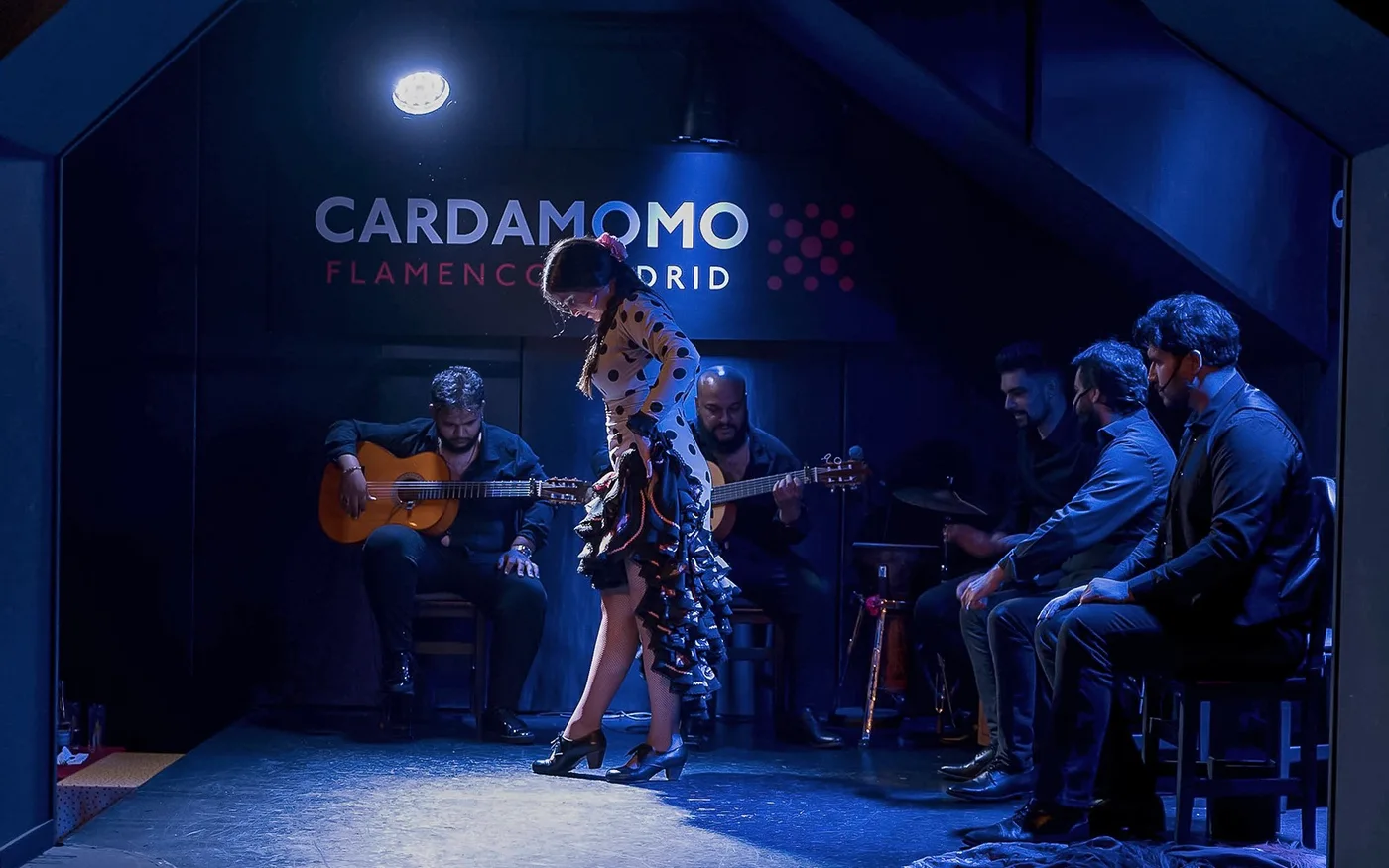 Dancer and musicians on the Cardamomo stage under blue lighting